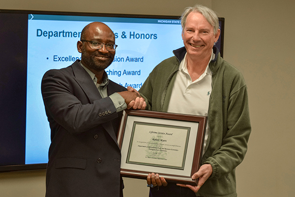 Dr. Bob Myers with AFRE Chair Titus Awokuse receiving his award