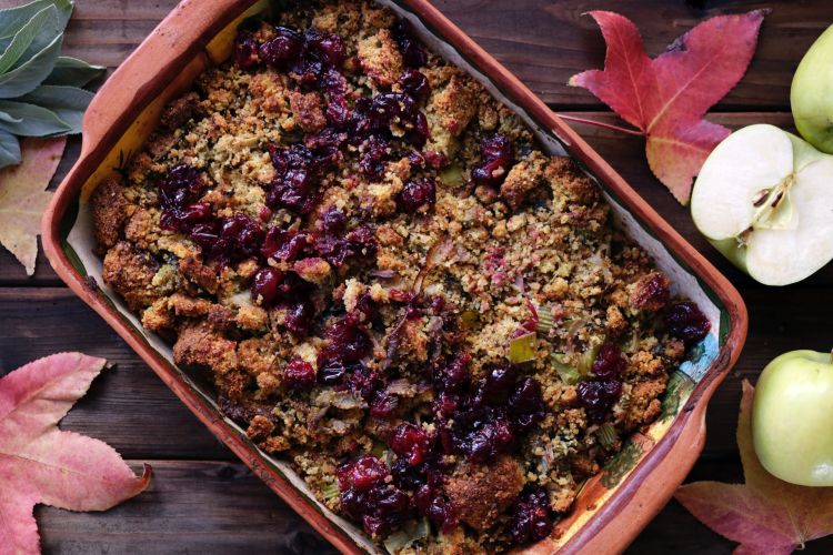 Stuffing in dish topped with cranberries.
