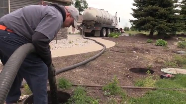 Man assessing a septic tank; for decorative purposes.