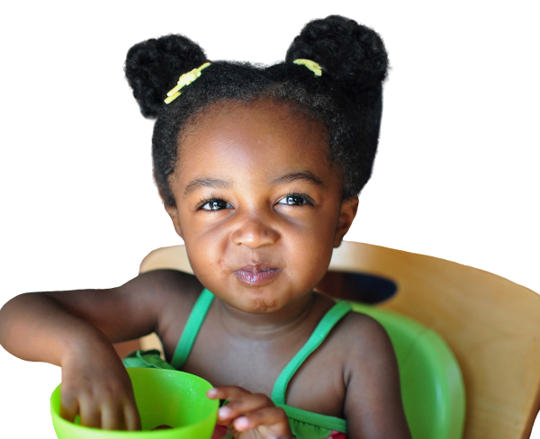 A young girl is eating food from a bowl.
