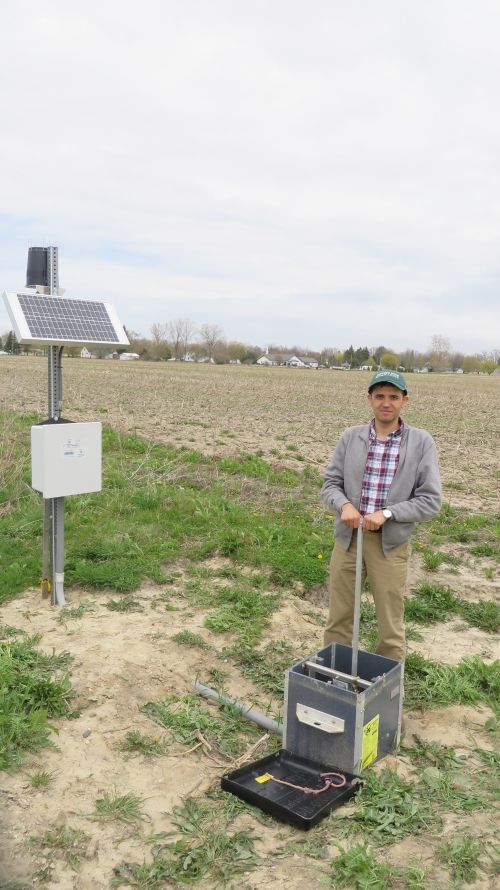 Ehsan Ghane stands with a controlled drainage structure in Elkton, MI. Photo credit: Anonymous 
