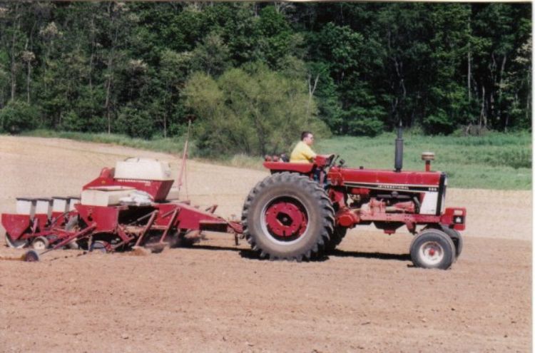 A farmer using his tractor to plant crops