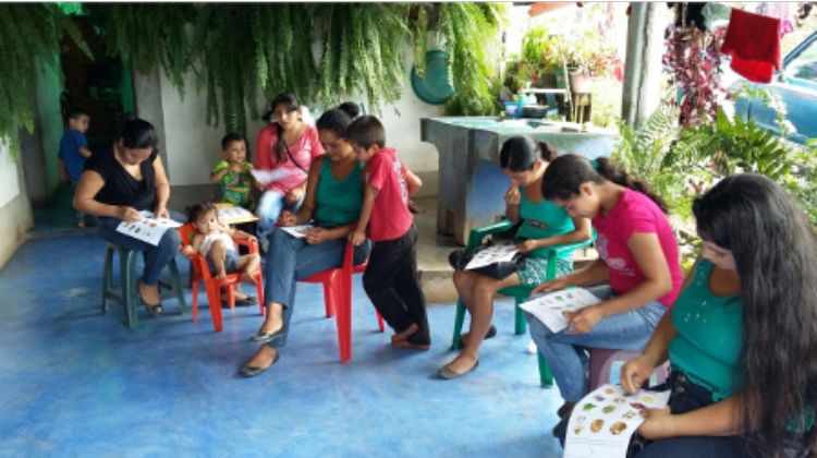 Women and children sit together for a nutrition education session