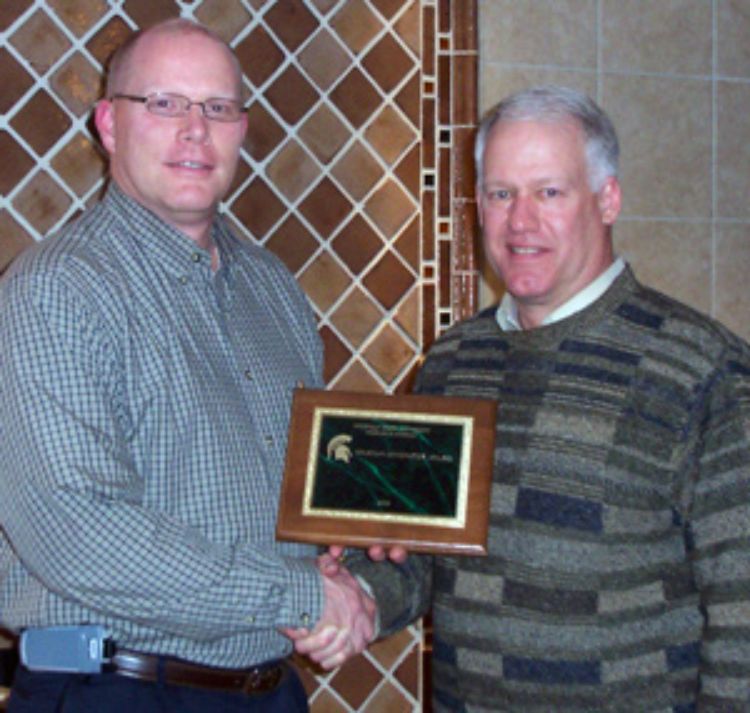 Doug Carmichael (right), manager of the Lake City Experiment Station, accepts the 2009 Spartan Innovator Award from Ben Darling.