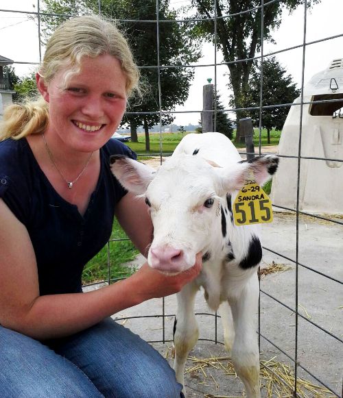 2015 International Youth Exchange participant Sandra Wefer from Germany with a calf born during her stay with one of her Michigan host families.