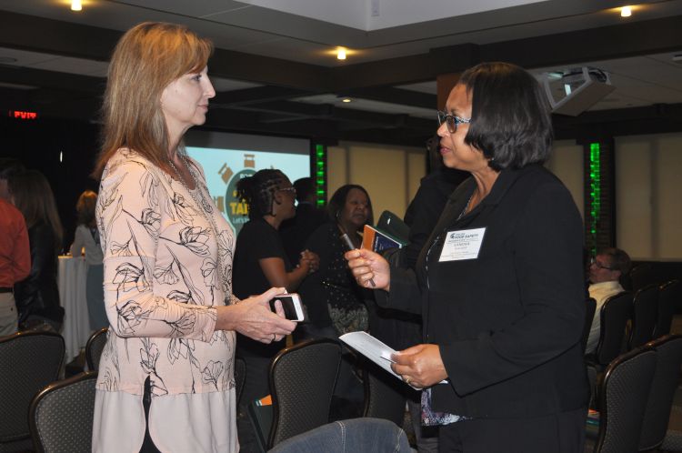 Sandra Walker talks with an audience member after Food@MSU's Our Table conversation on food safety in May 2018.