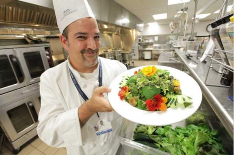Hospital Chef Steve Delidow showing off a dish made with ingredients from the greenhouse. (Photo Credit: Patricia Beck/DFP).