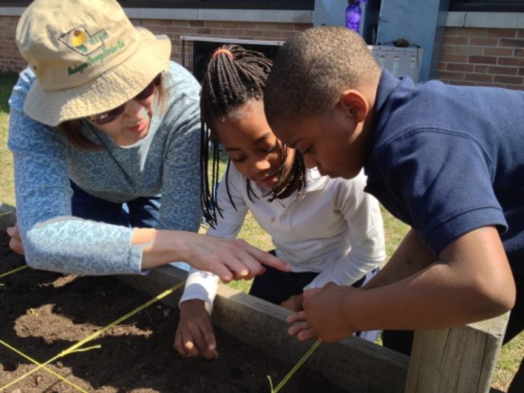 The Coalition for Community Development helps students at MLK Elementary plant carrots. Photo courtesy of cffmc.org.