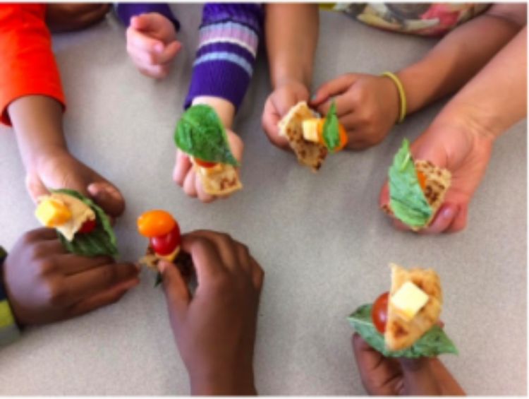 Children’s hands holding healthy snacks. Photo Credit: Andrea Collier