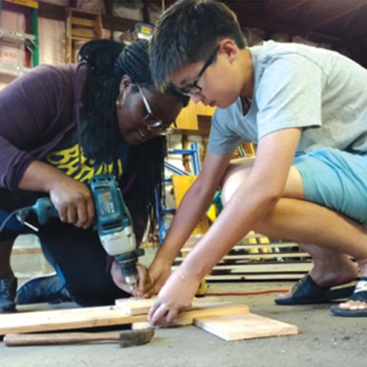 Two students constructing window shutters.