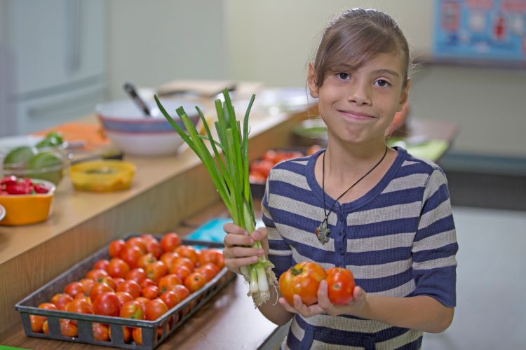 Young girl holding vegetables
