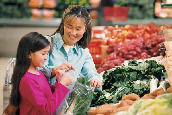 A woman and her daughter shop for fresh produce.