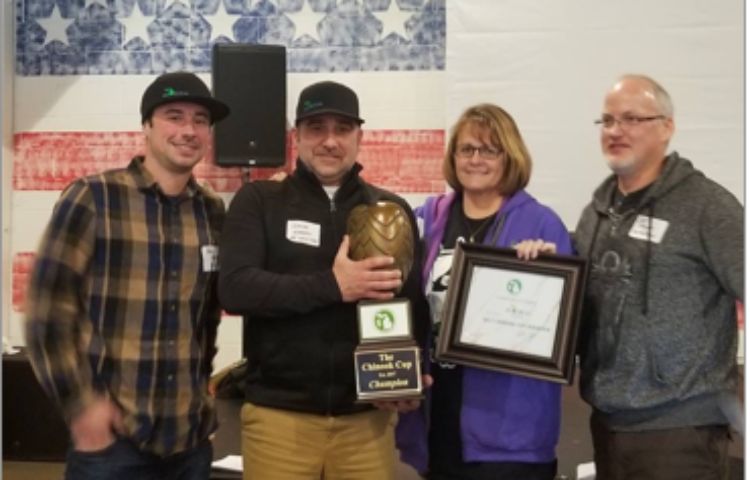 MI Local’s Alex Wiesen (left) and Jason Warren (tightly gripping trophy) receive the 2017 Chinook Cup from the Hop Growers of Michigan.
