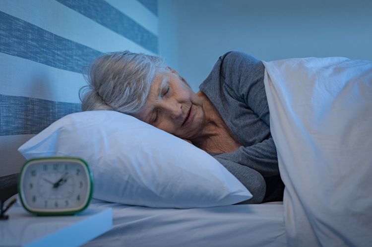 An older woman sleeping in bed.