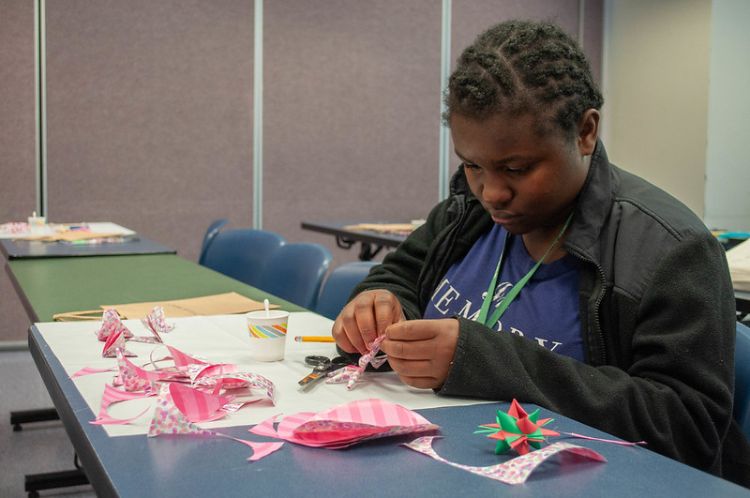 A young person making paper oragami.