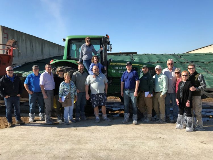 A group of people standing in front of a tractor