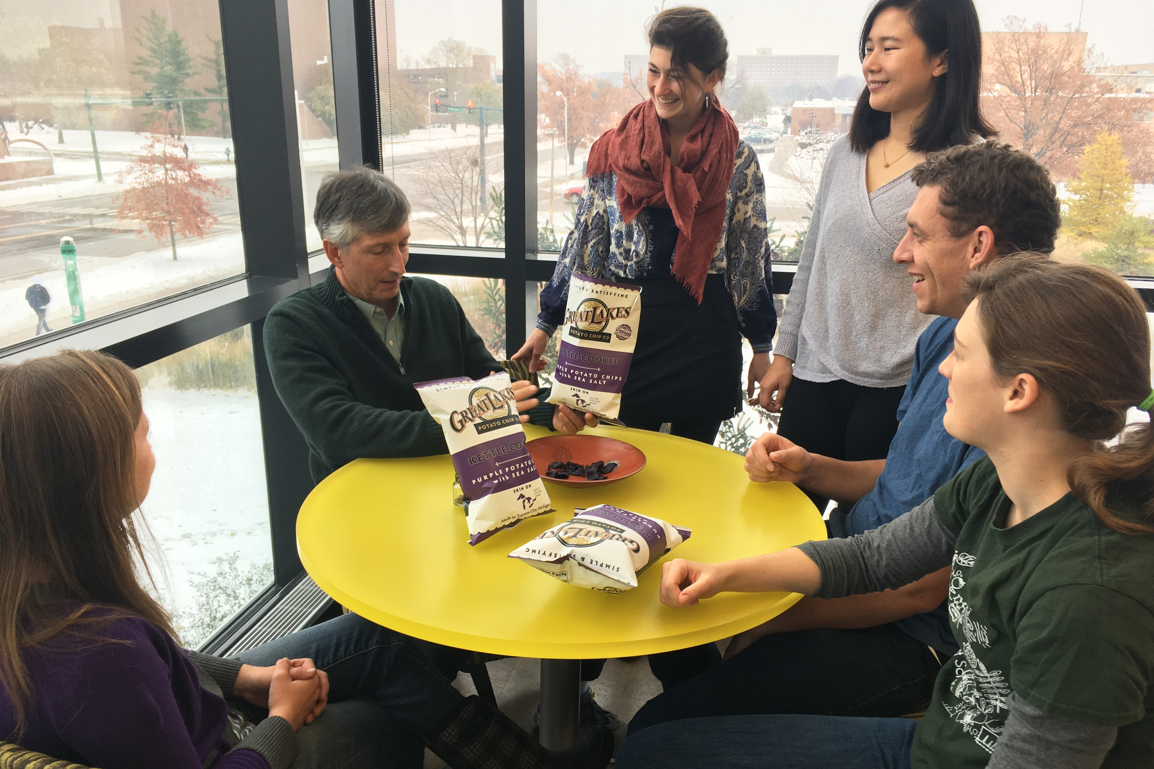 MSU potato breeder Dave Douches eats purple potato chips with students