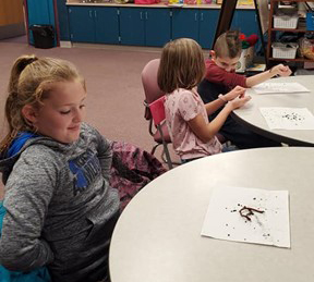 Students examining worms