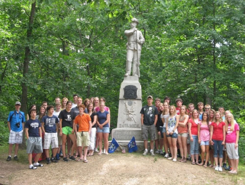 2.	The Michigan Citizenship Washington Focus delegates stop at the Gettysburg  monument honoring the Michigan 24th at the battlefield site where they fought.