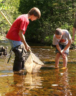 Rogers City Elementary students taking samples in Trout River.