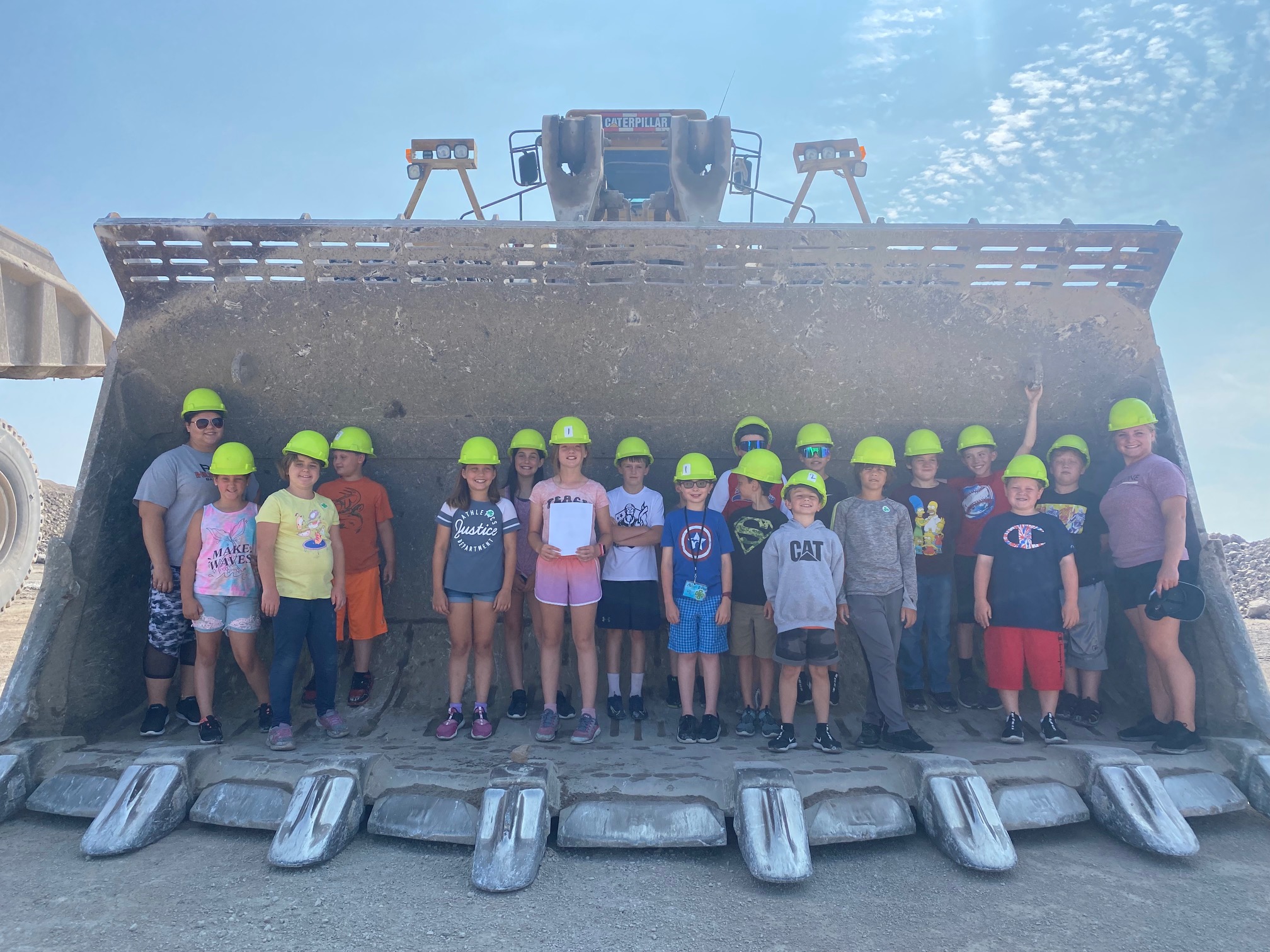 Presque Isle 4-H'ers standing in the bucket of a piece of equipment while on a field trip.