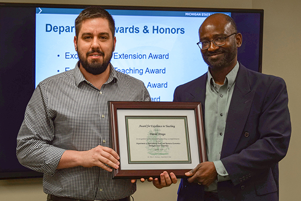 Dr. David Ortega with AFRE Chair Titus Awokuse receiving his award