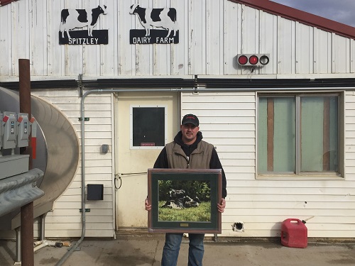 Chris Spitzley following presentation of a framed cow print at Spitzley Dairy Farm