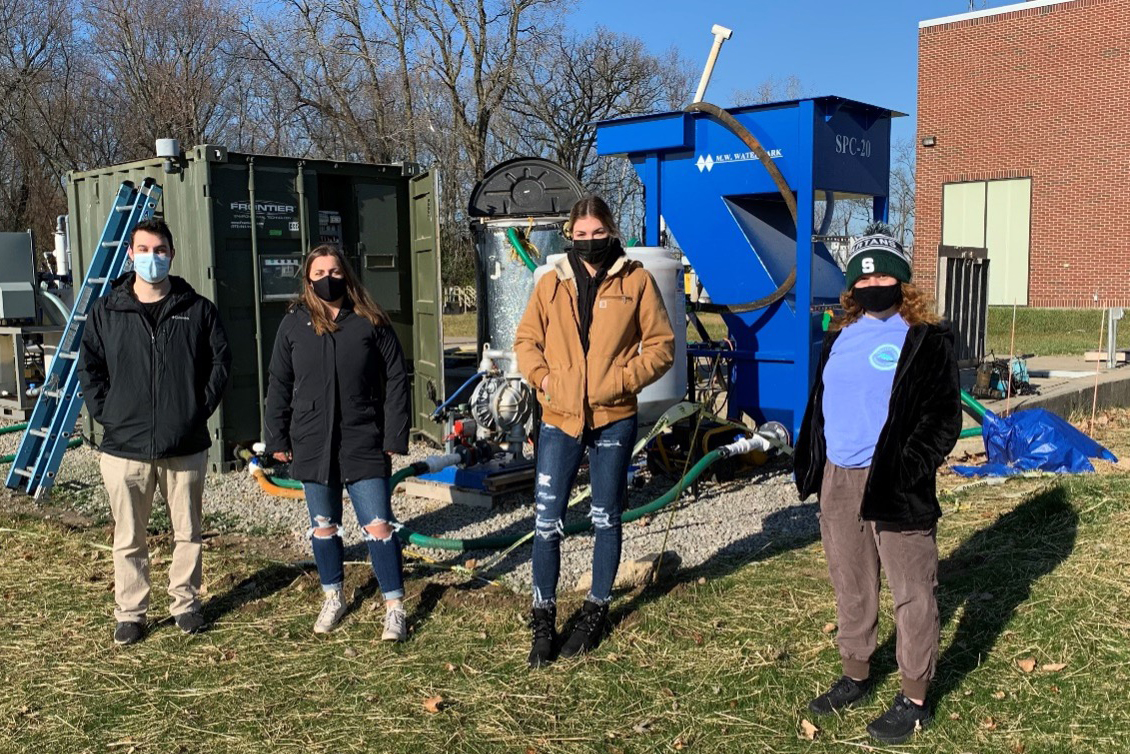 Students in front of the wastewater treatment plant while wearing masks and social distancing