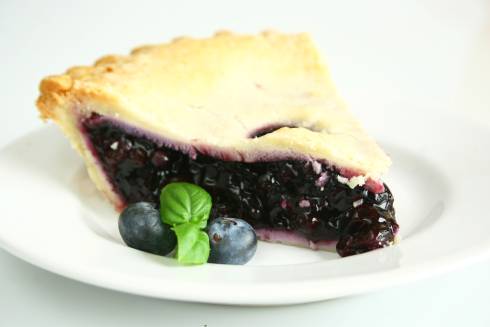 Slice of blueberry pie on plate.