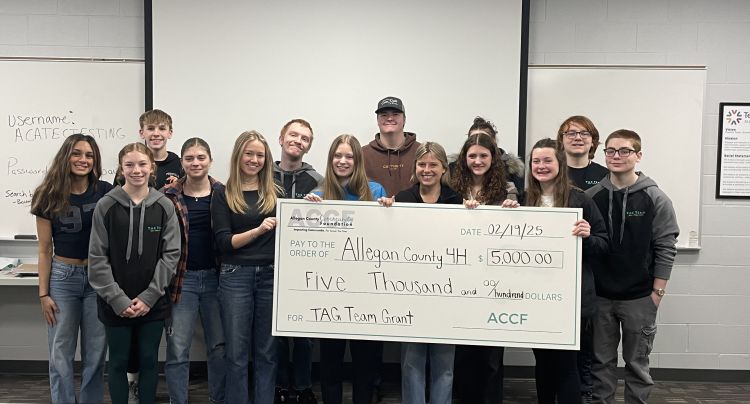 A group of youth holding up an extra large check made out to Allegan County 4-H.