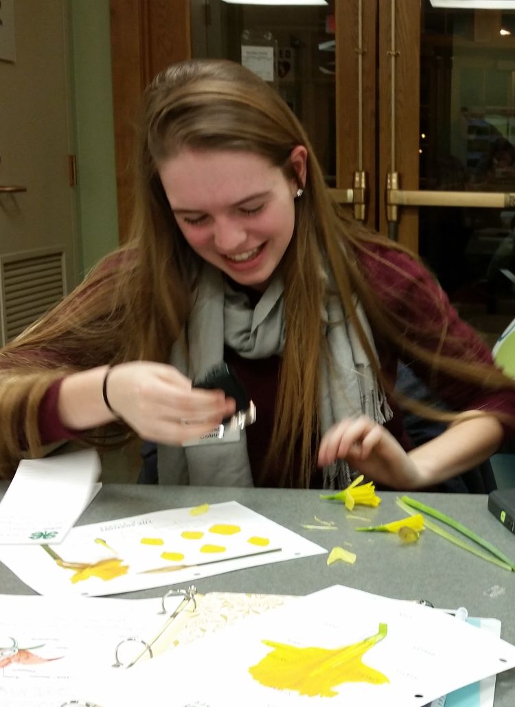 A girl laughing at a project she is working on