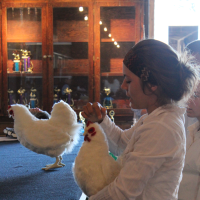 A young person showing a stuffed bird model.