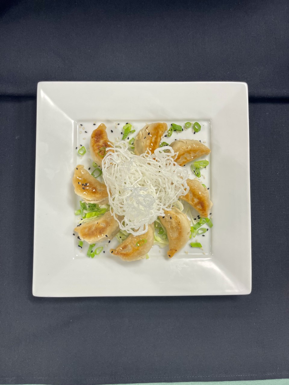 Pork potstickers arranged on plate.