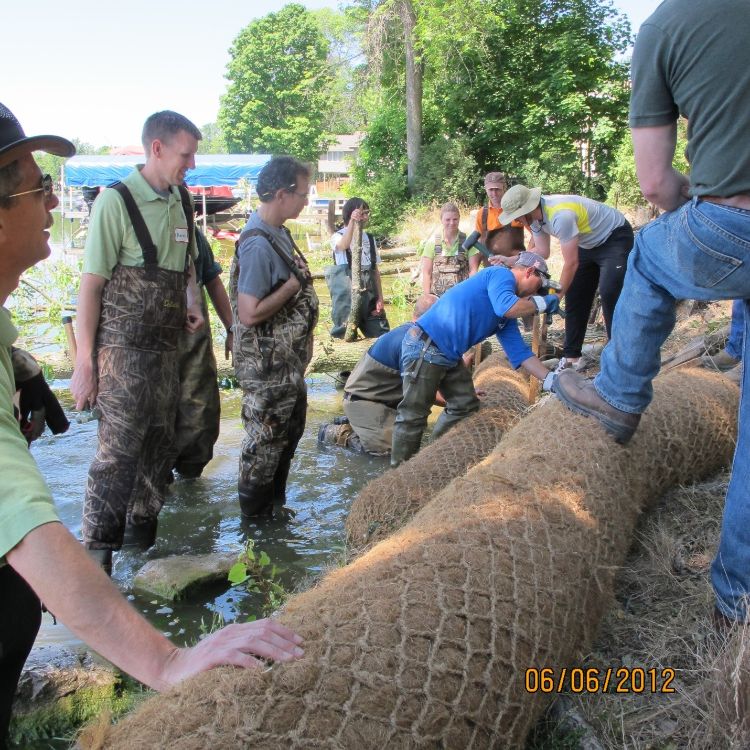 Certified Natural Shoreline Trainees installing a coir log to help stabilize a lake shoreline as part of the training’s demonstration day. Photo credit: Jane Herbert