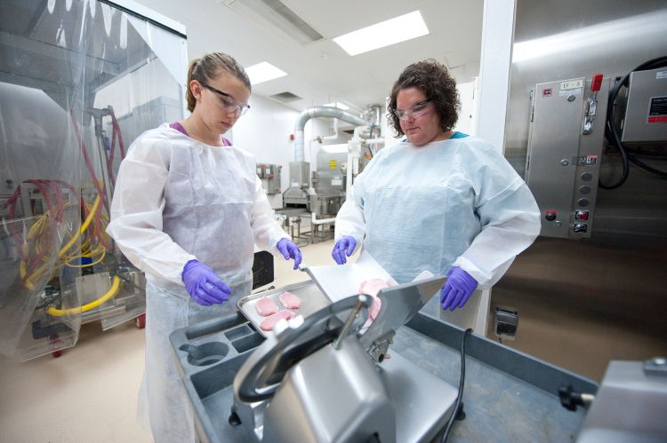 Two female students conduct research in a lab.