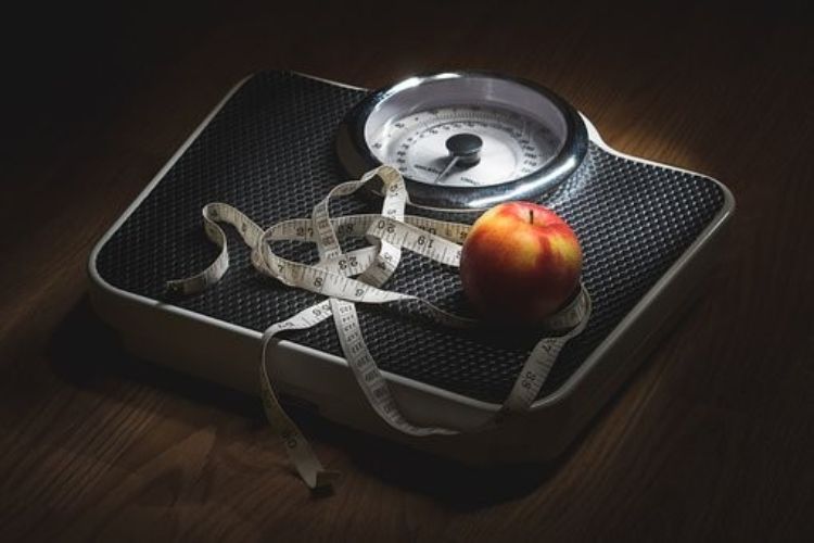 Scale with apple and tape measure