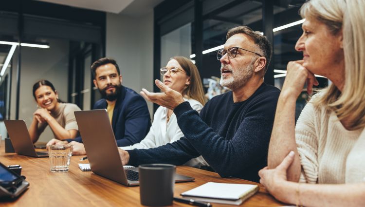 Five individuals at a conference table conducting a board meeting. For decorative purposes.