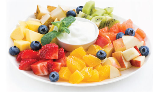 A fruit platter with dip in the middle.