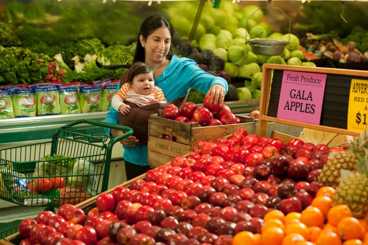 A mother and child grocery shopping for produce.