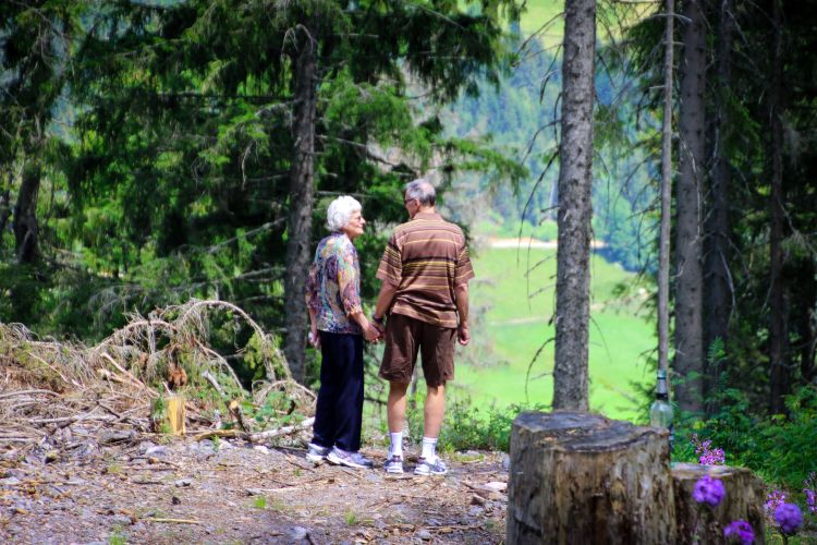 Two people standing in a forest.