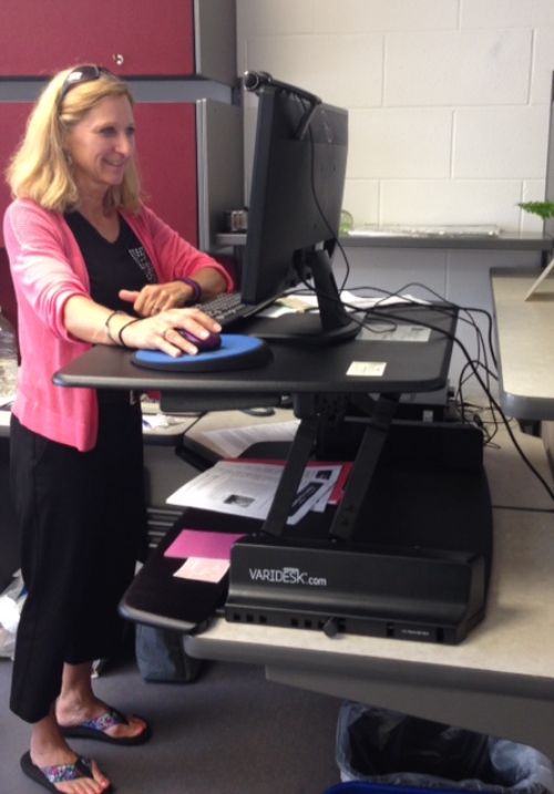 Colleague Luann has found a standing option at her desk to alleviate back pain