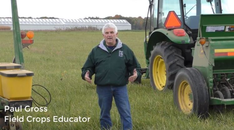 Paul Gross standing in front of farm equipment