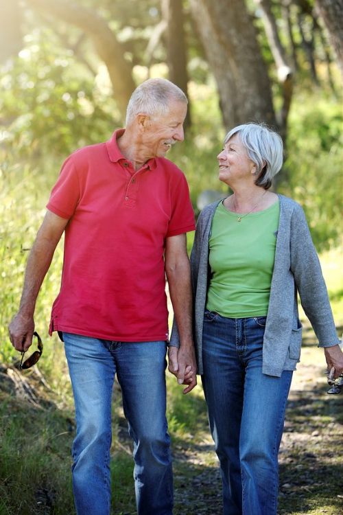 An older couple walking, holding hands