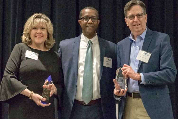 Brenda Reau and Tom Lyons of the MSU Product Center pose with Darryl Hunter from the Michigan Talent Investment Agency after receiving their awards.