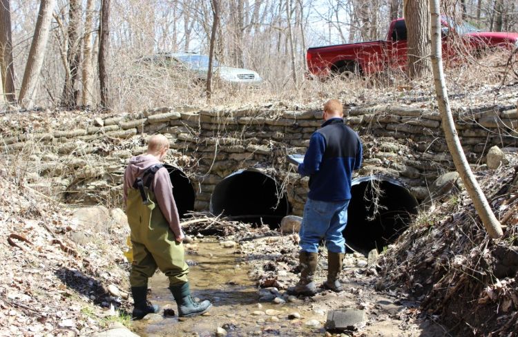 Volunteers assess a road stream crossing for multiple concerns including whether it is barrier to fish and other aquatic organism movement, is it causing erosion, and what condition the culvert in. Photo credit: Clinton River Watershed Council.