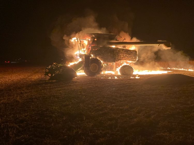 A combine completely ingulfed in flames.