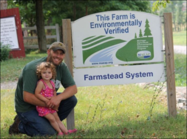 Ben Tirrell in front of the MAEAP sign at Tirrell  Farmstead Specialties. Photo courtesy of MAEAP.org and Tirrell Farms.