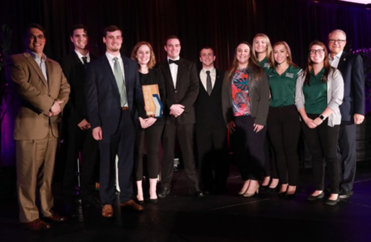 Photo of the MSU team receiving their trophy.