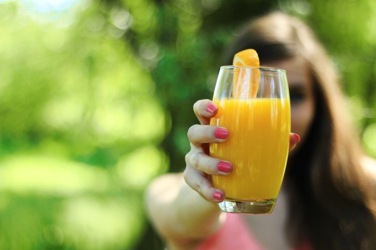 Woman holding a glass of juice.