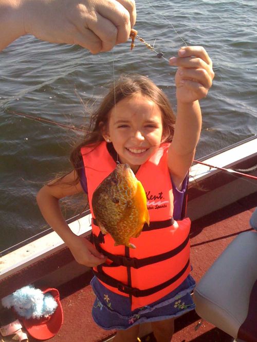 A young angler shows off a pumpkinseed fish caught on the Huron River. | Michigan Sea Grant